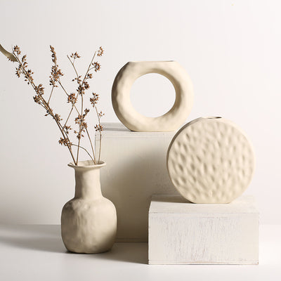  Set of Scandinavian ceramic vases made of primitive white pottery, displayed on a wooden shelf as minimalist home decor ornaments 