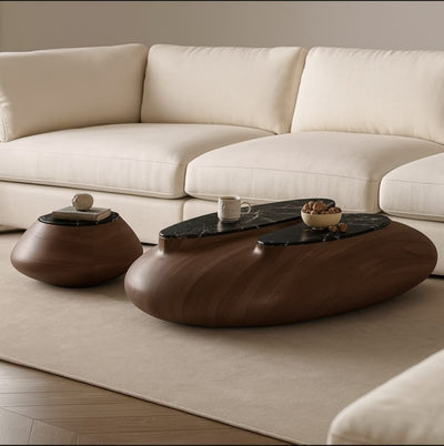 Top view of two pebble-shaped walnut coffee tables showcasing minimalist design and rich wood grain.

