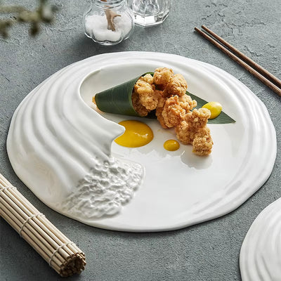 Gourmet plating on French wave-rim ceramic plate with leaf wrap and yellow sauce